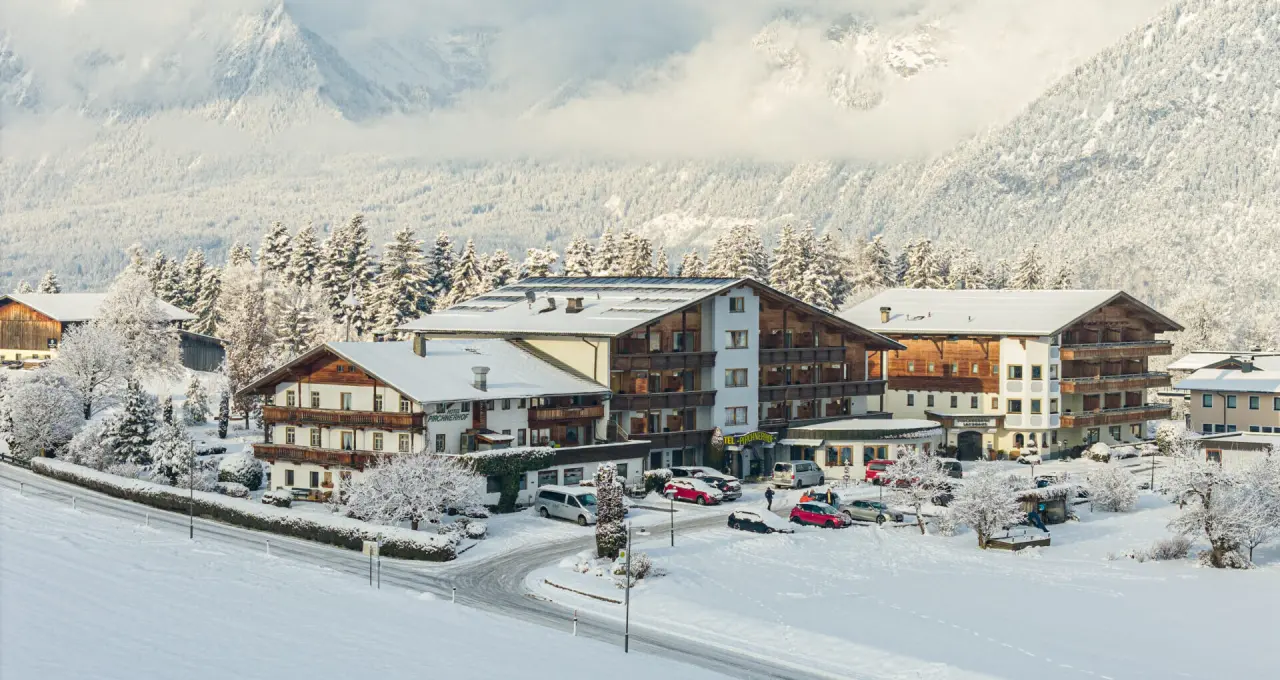 Aktiv- & Wellnesshotel Pirchnerhof im Winter, umgeben von verschneiten Bergen und Wäldern in Reith im Alpbachtal.