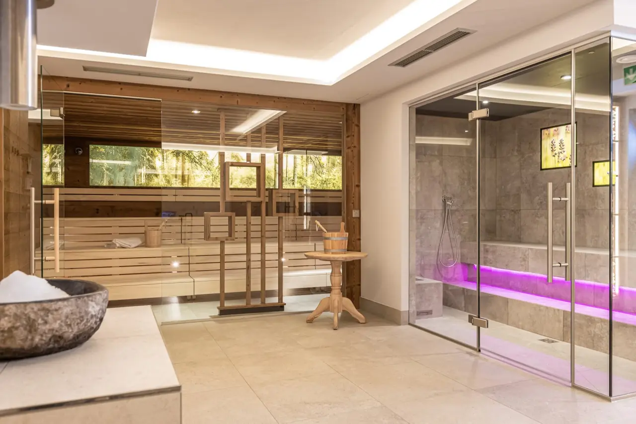 Moderne finnische Sauna und Dampfbad mit lila Beleuchtung im Wellnessbereich des Aktiv- & Wellnesshotel Pirchnerhof.