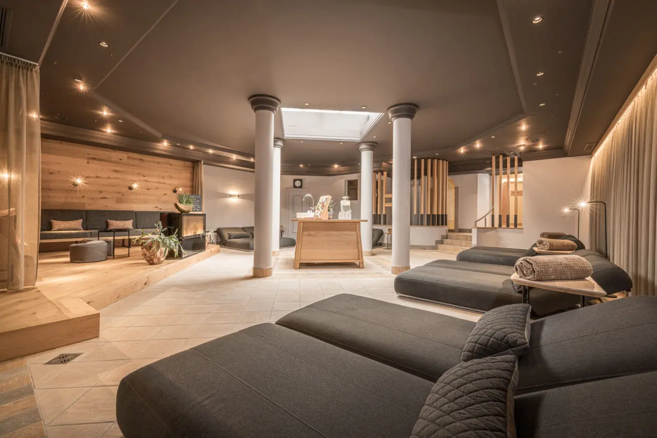 Grosszügiger Ruheraum mit bequemen Liegen und Holzdetails im Spa des Aktiv- & Wellnesshotel Pirchnerhof.