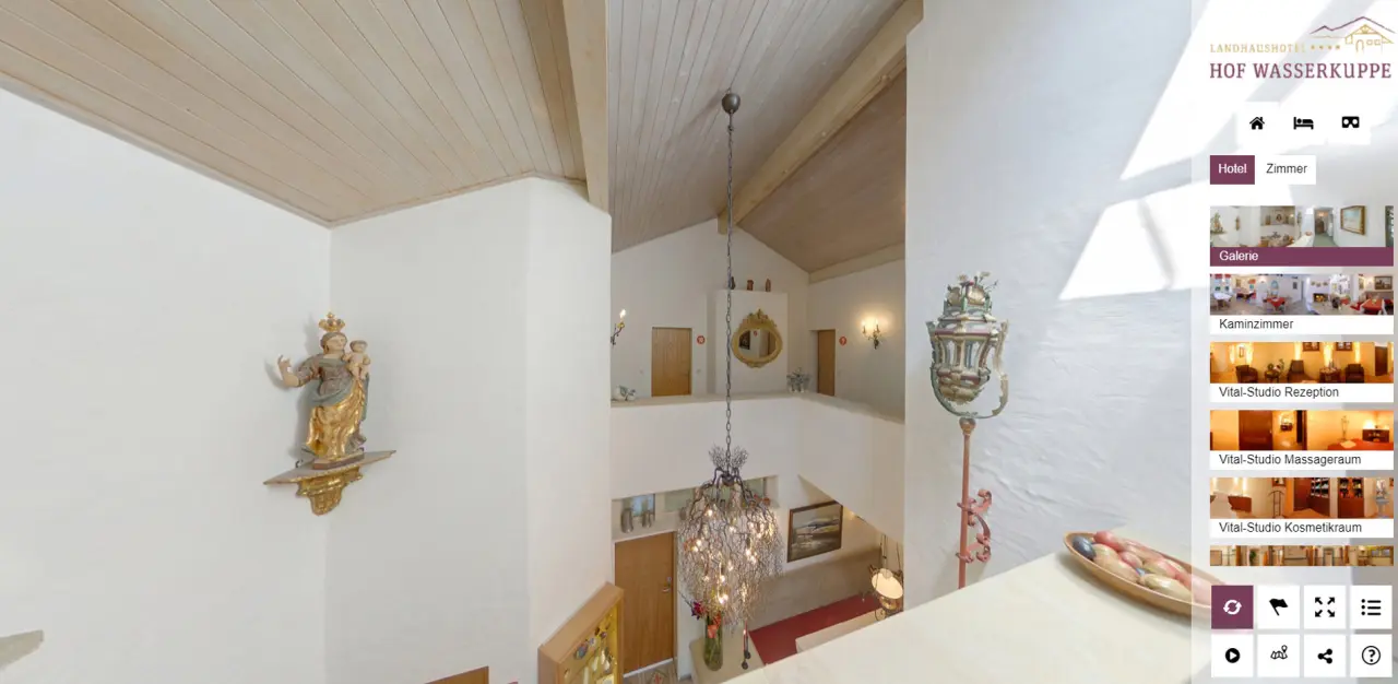 Heller Empfangsbereich oder Treppenhaus im Landhaushotel Hof Wasserkuppe mit Kronleuchter und traditioneller Dekoration.