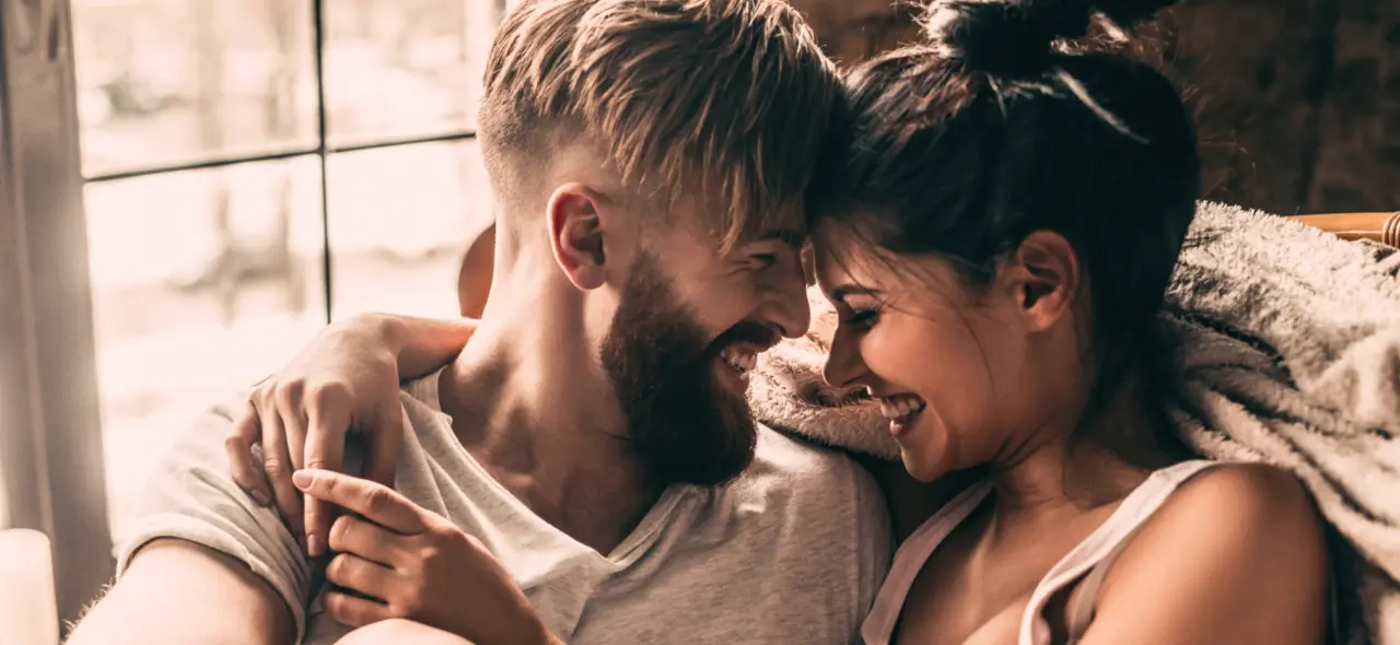 Glückliches Paar entspannt und lacht im Alpenlove - Adult Spa Hotel, das eine romantische Atmosphäre vermittelt.