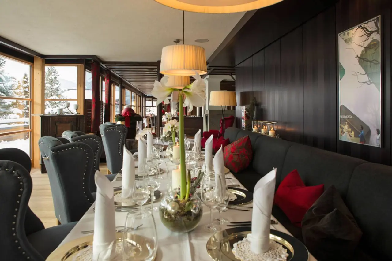 Elegant gedeckter Restaurantbereich mit Blick auf die verschneite Winterlandschaft im Wellness Hotel Zinnkrügl.