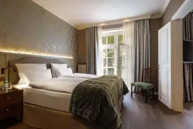 Helles, komfortables Doppelzimmer mit stilvoller Einrichtung und Fensterblick im Hotel Stadt Hamburg.