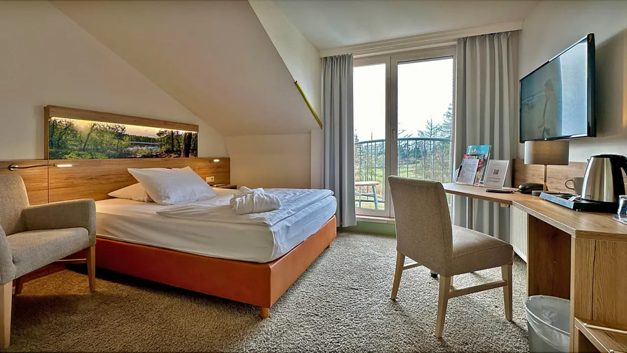 Gemütliches Hotelzimmer mit Doppelbett, Balkon und Schreibtisch im Hotel & Spa Sommerfeld.