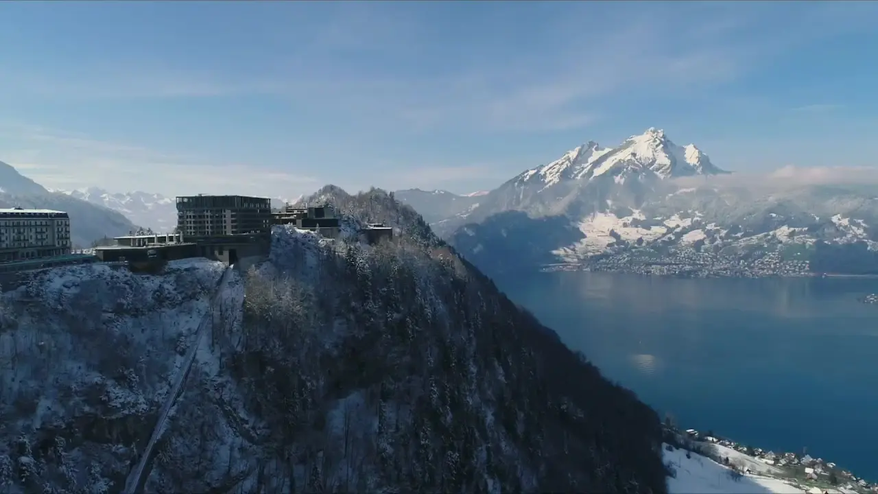 Bürgenstock Resort Lake Lucerne im Winter: Luxushotel auf dem Berg mit Panoramablick auf verschneite Alpen und Vierwaldstättersee.