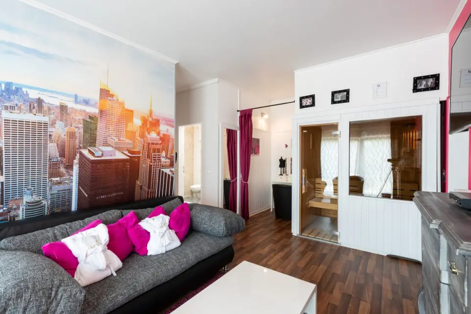 Suite mit privater Sauna, gemütlichem Sofa und New York Wandbild im Wellnesshotel Ziegelruh.