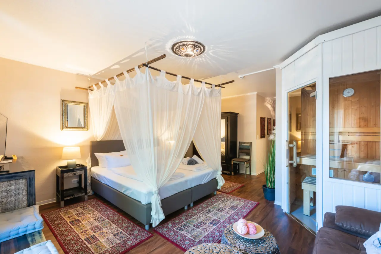 Luxuriöses Hotelzimmer mit Himmelbett und privater Sauna im Wellnesshotel Ziegelruh für entspannte Stunden.