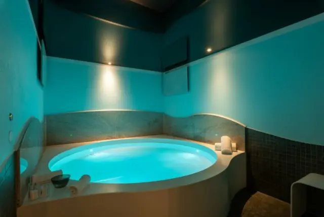 Blau beleuchteter Whirlpool im privaten Spa-Bereich des Wellnesshotel Ziegelruh, ideal zur Entspannung.