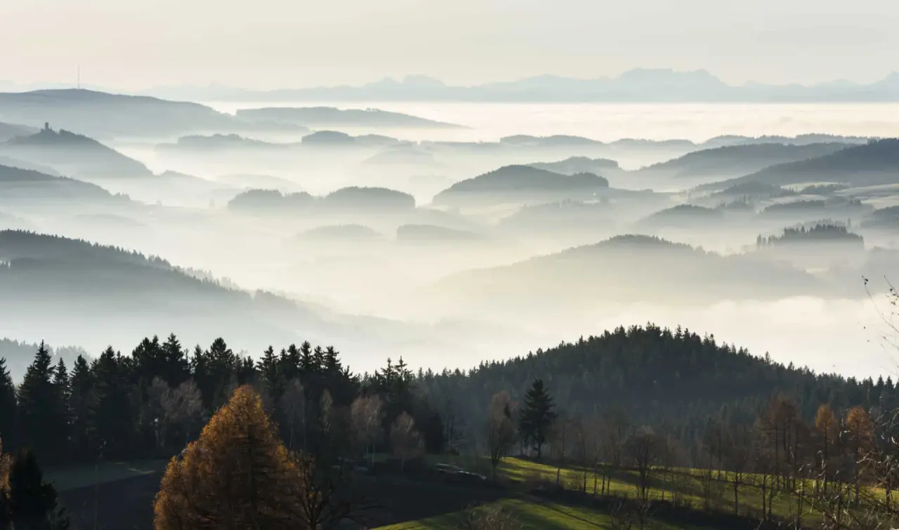 Malerisches Bergpanorama mit nebelverhangenen Tälern und Wäldern rund um das AVIVA****s make friends Hotel.