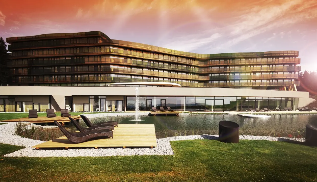 Aussenansicht des modernen Hotel AVIVA****s make friends mit Natur-Badeteich und Liegedecks.