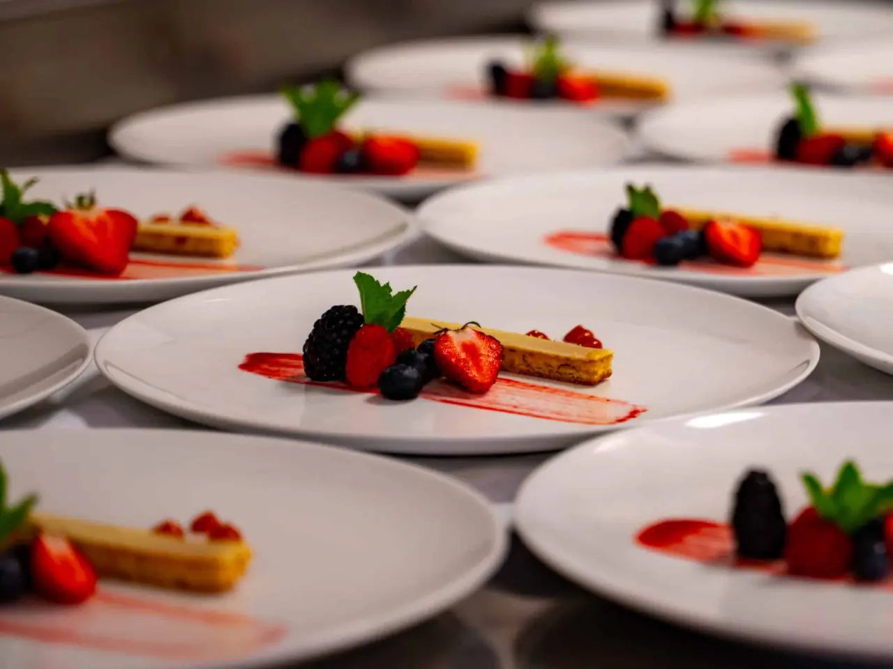 Professionell angerichtete Desserts mit frischen Beeren und Minze im Restaurant des AVIVA****s make friends Hotel.