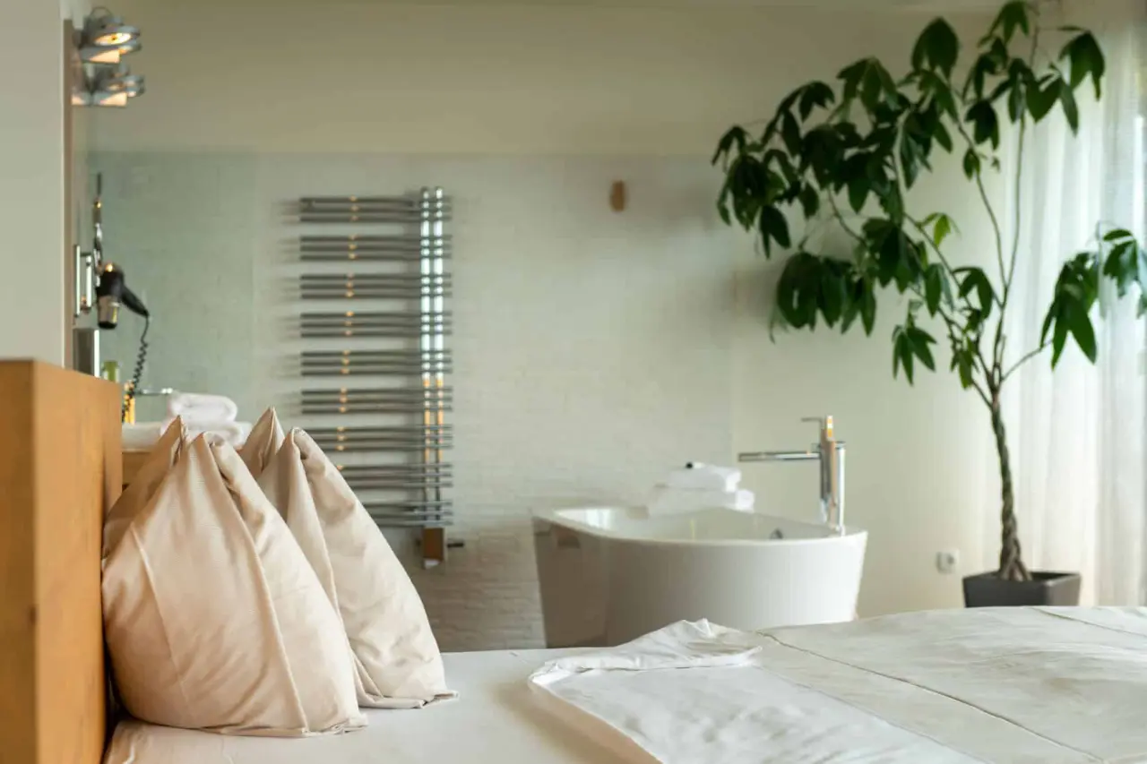 Modernes Hotelzimmer im AVIVA****s make friends mit freistehender Badewanne und komfortablem Bett.