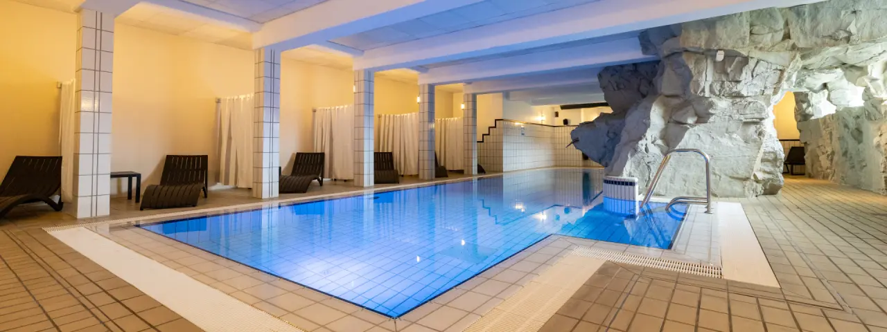 Innenpool mit Felswand und Liegebereich im Hotel Seeblick, ideal zur Entspannung und Erholung.