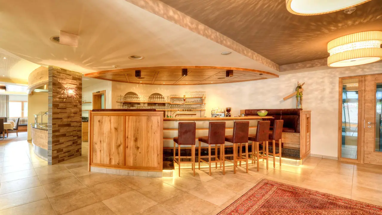 Gemütliche Hotelbar mit Holztheke und bequemen Barhockern im Wellness- & Familienhotel Panorama.
