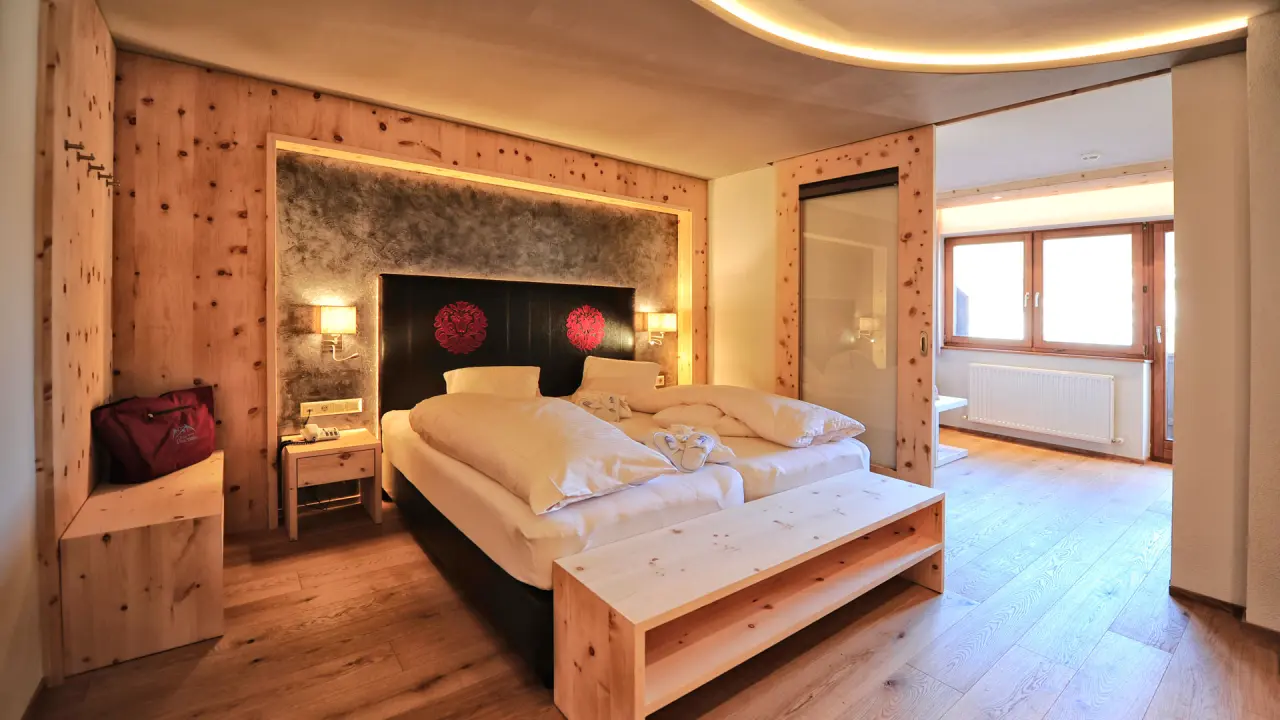 Gemütliches Doppelzimmer mit Holzelementen und bequemen Betten im Wellness- & Familienhotel Panorama.