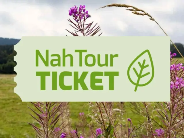NahTour TICKET des Hotel Kammweg am Rennsteig, mit grüner Wiesenlandschaft und lila Blumen im Hintergrund.
