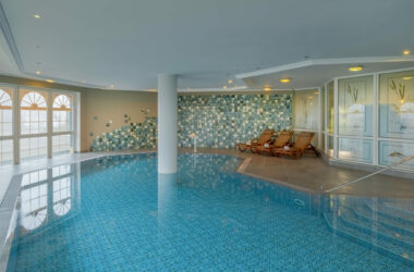 Grosszügiger Innenpool mit Mosaikwand und Liegebereich im Hotel Kammweg am Rennsteig.