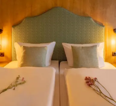 Gemütliches Doppelzimmer mit Holzwand und bequemen Betten im Hotel Kammweg am Rennsteig.