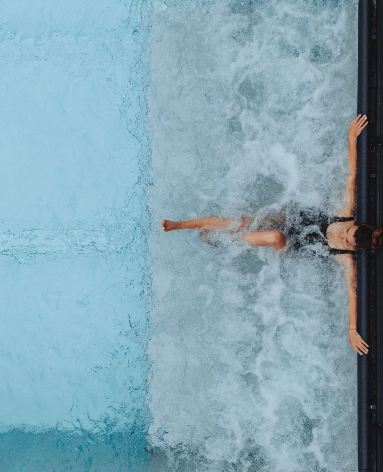 Person entspannt in sprudelndem Whirlpool im Wellnessbereich des Sonne Mellau - Feel good Hotel.