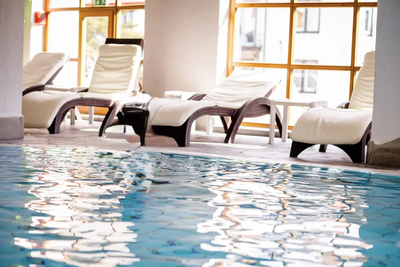 Entspannender Innenpoolbereich mit bequemen Liegen und Tageslicht im Holzschuh’s Schwarzwaldhotel.
