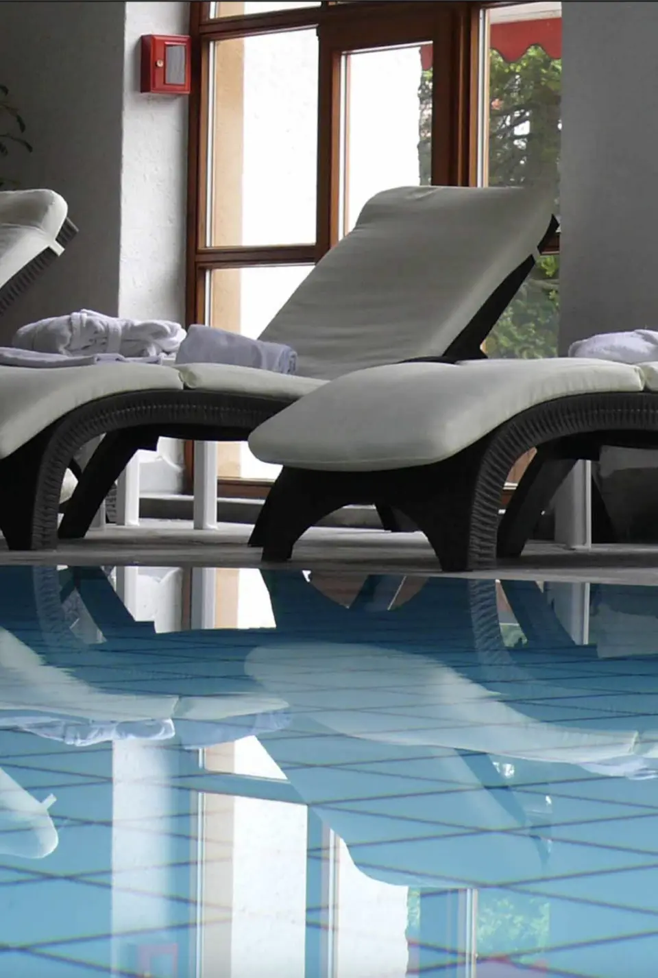 Entspannungsbereich am Innenpool mit bequemen Liegestühlen im Holzschuh’s Schwarzwaldhotel.