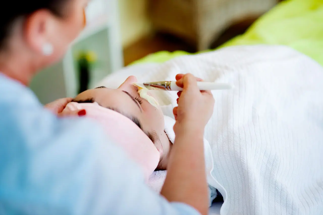 Gesichtsbehandlung im Spa-Bereich von Holzschuh’s Schwarzwaldhotel. Eine Kosmetikerin trägt eine Maske auf.