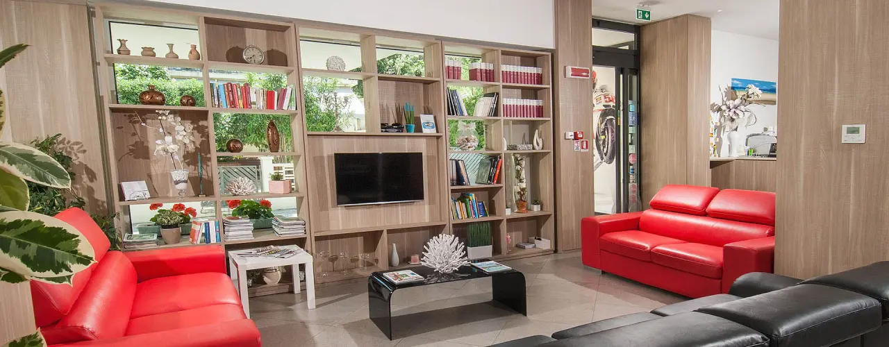 Hotel Atlantic & Spa in Gabicce Mare – Gemütliche Lobby mit roten Sofas und Bibliothek | Wellnesshotel Adria