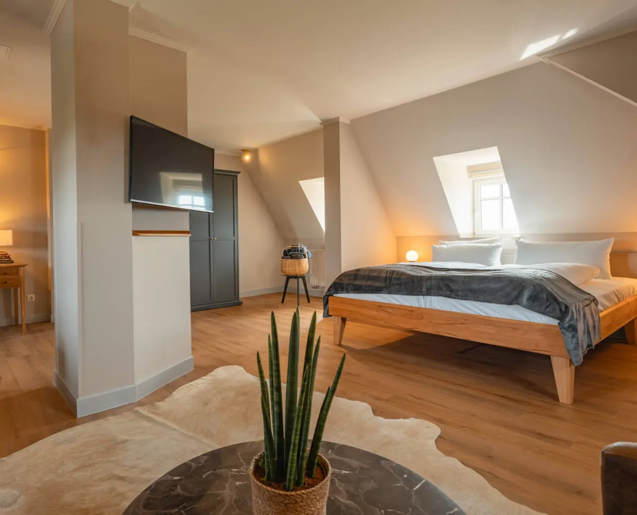 Modernes Doppelzimmer mit Holzbett, Dachschräge und TV im Relaxhotel Sachsenbaude. Ideal für entspannte Nächte.
