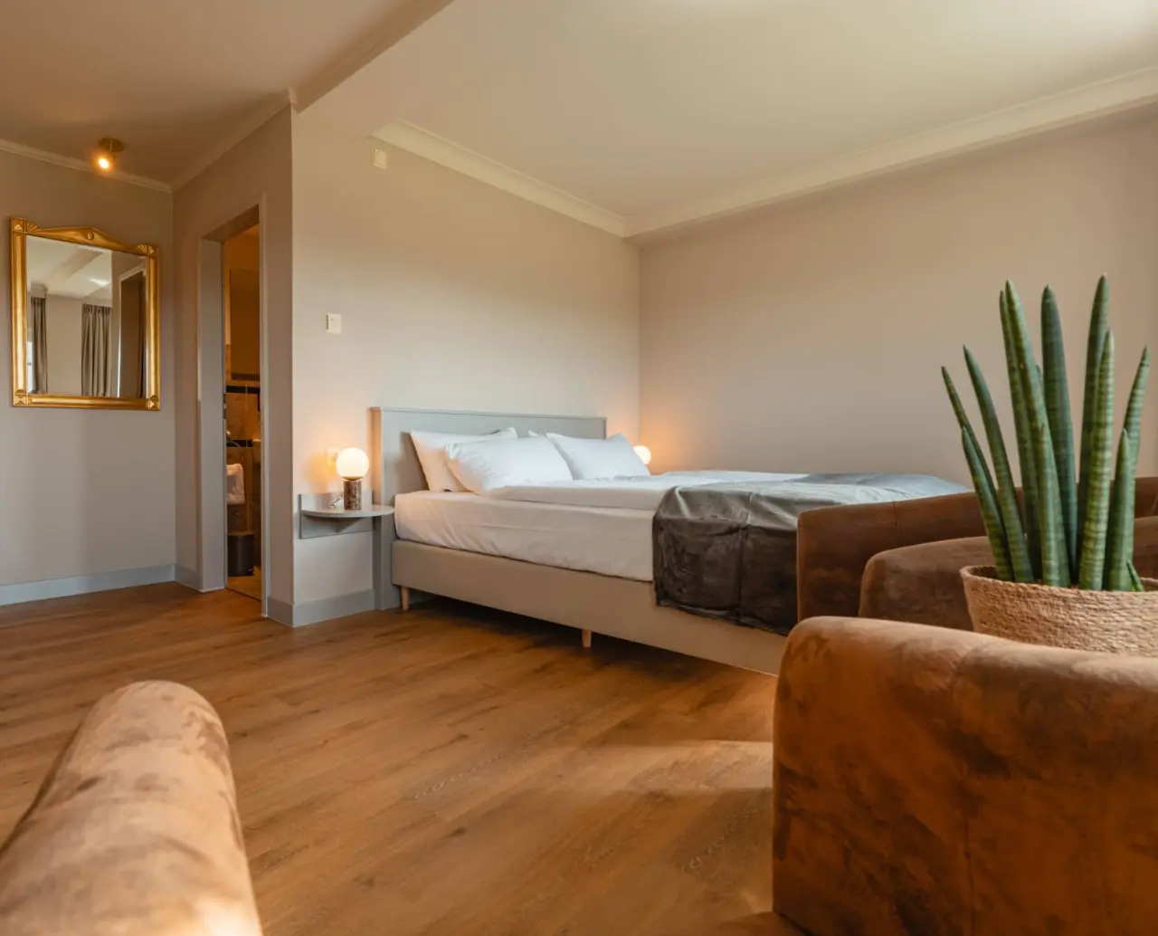 Komfortables Doppelzimmer mit Holzboden und gemütlichen Sesseln im Relaxhotel Sachsenbaude.