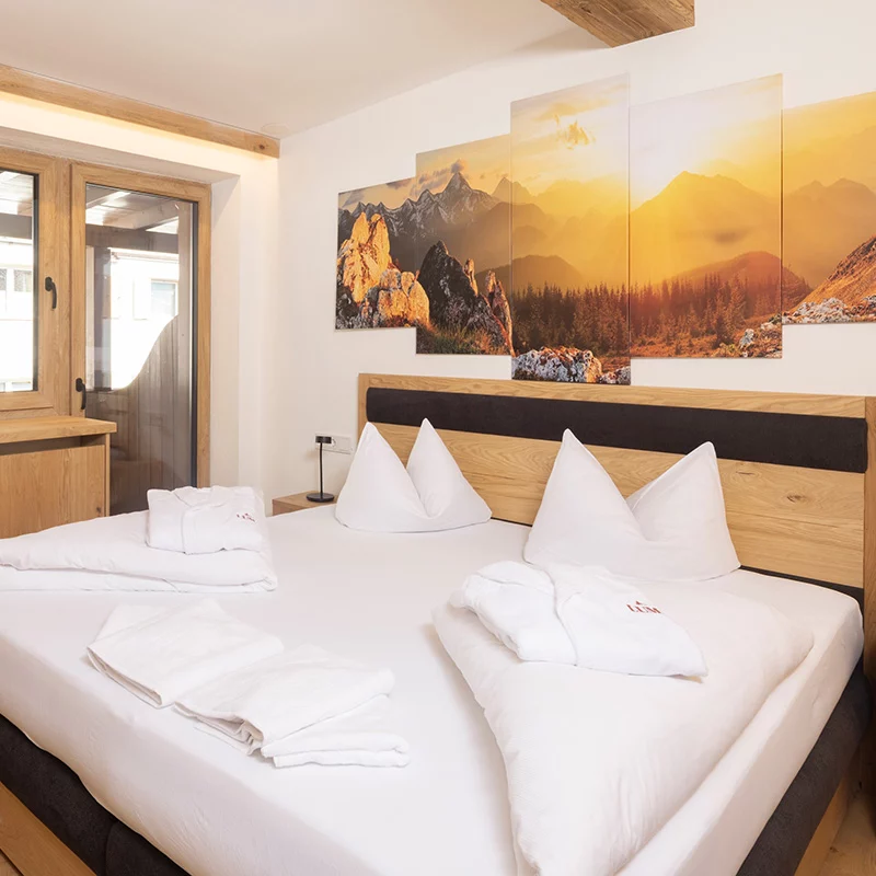 Hotel Brennerspitz in Neustift im Stubaital – Gemütliches Schlafzimmer mit Bergbildern | Wellnesshotel Stubaital