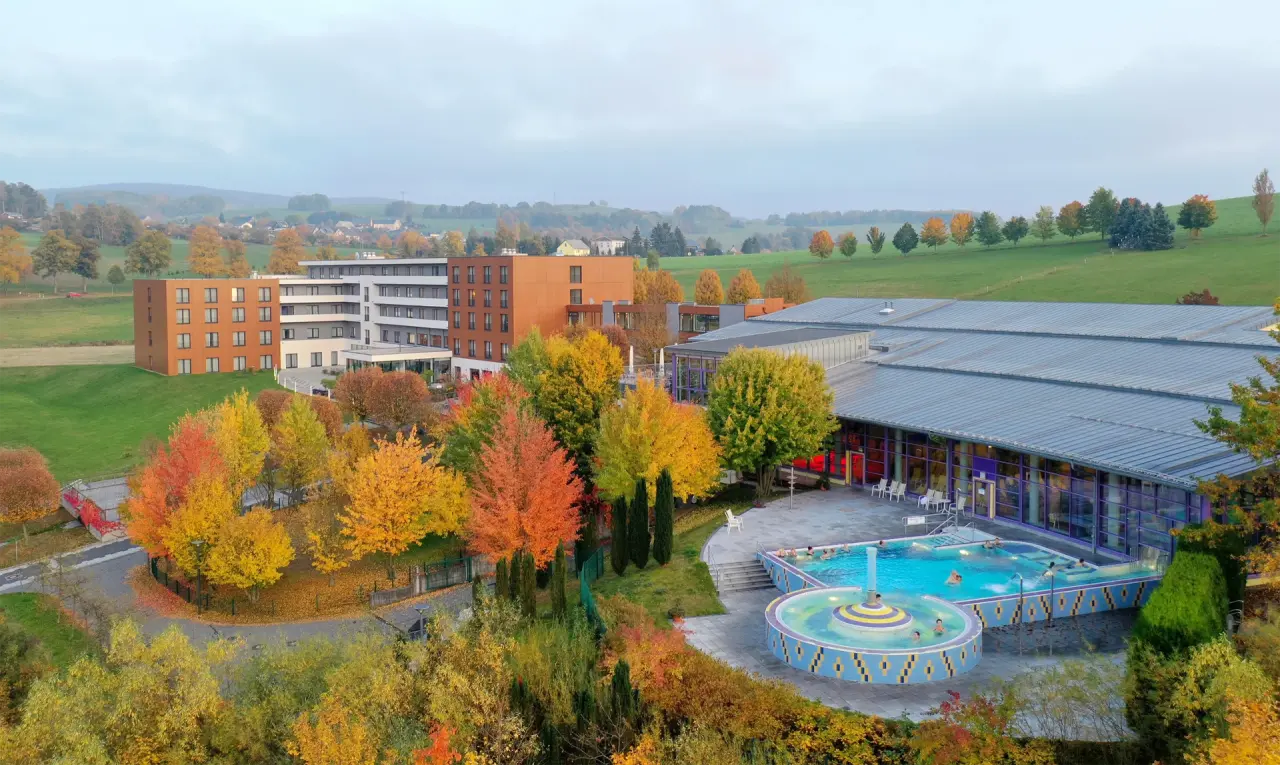Luftaufnahme des Hotel Sante Royale Bad Brambach mit Aussenpool und herbstlicher Landschaft.