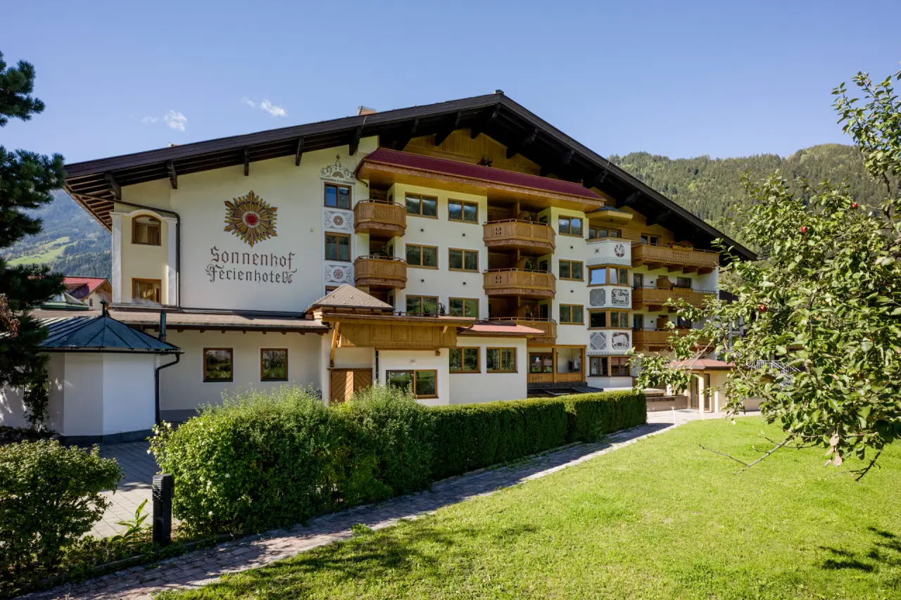 Aussenansicht des Ferienhotel Sonnenhof**** mit traditioneller Architektur und grüner Umgebung in den Bergen.