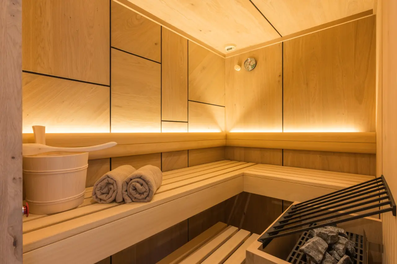 Moderne finnische Sauna mit Holzverkleidung, indirekter Beleuchtung und Saunazubehör im Ferienhotel Sonnenhof****