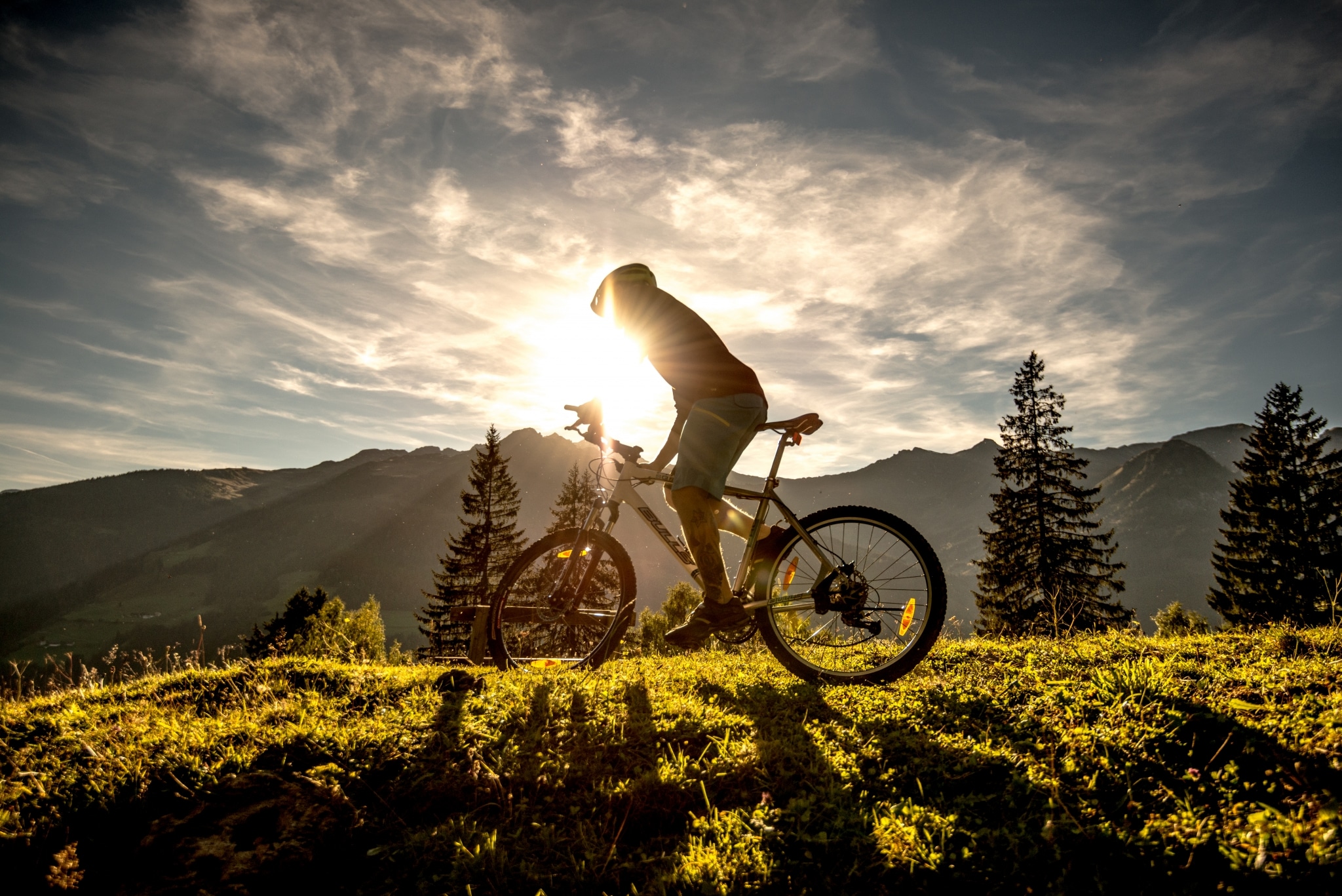 Das Alpenhaus Gasteinertal in Bad Hofgastein – Mountainbiker bei Sonnenuntergang in den Bergen | Wellnesshotel Gasteinertal