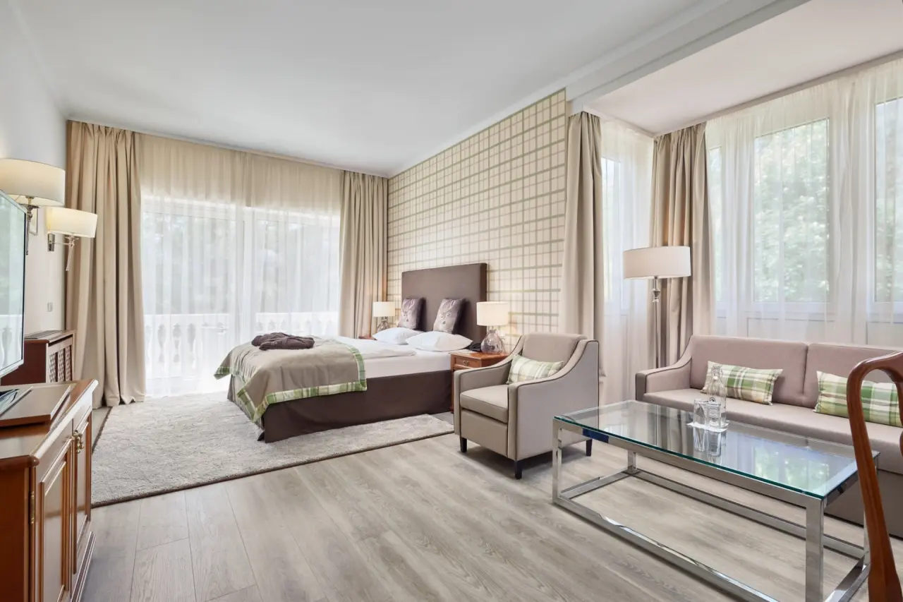 Helles, komfortables Doppelzimmer mit Balkon und Sitzbereich im Das Alpenhaus Gasteinertal.