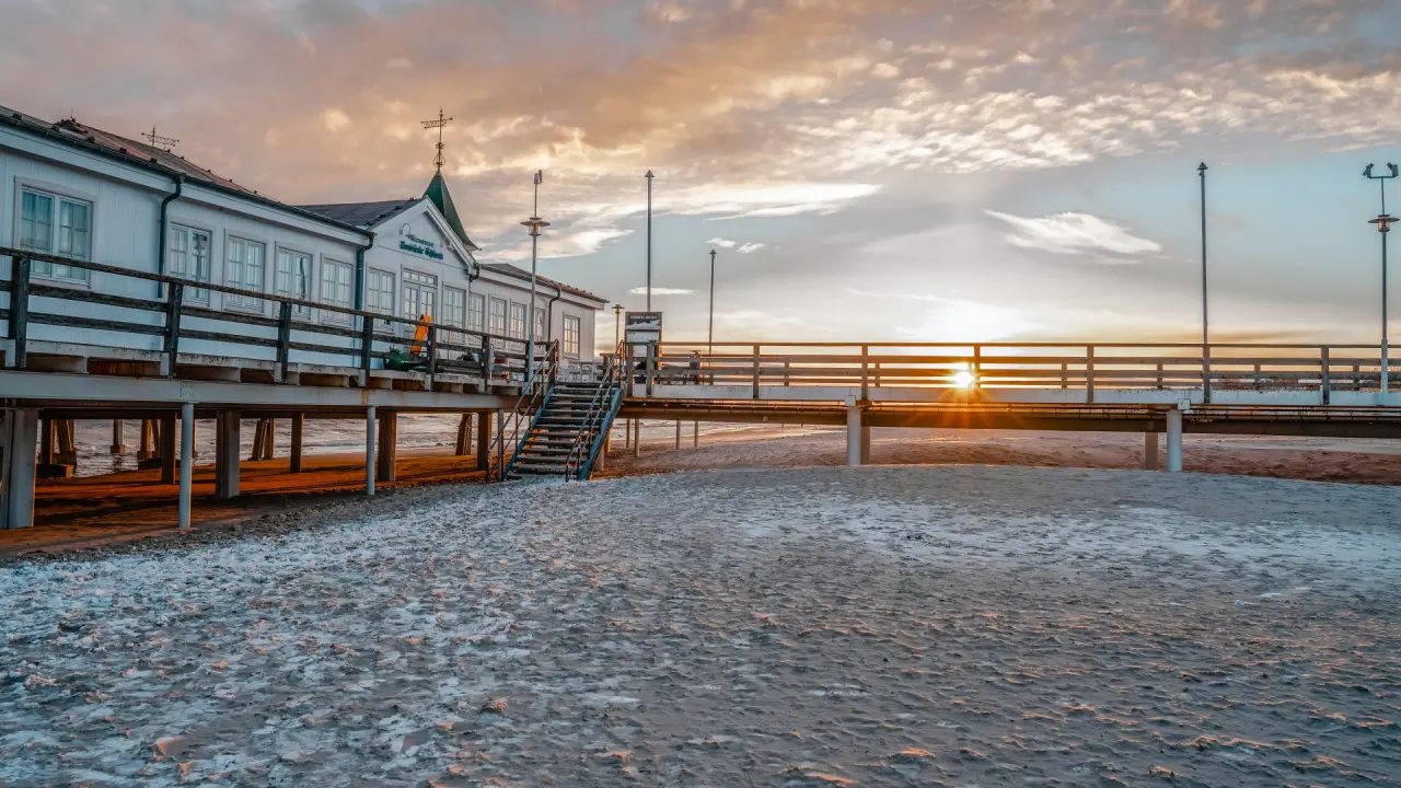 Sonnenuntergang an der Seebrücke Ahlbeck mit Strand im Vordergrund, nahe Das Ahlbeck Hotel & Spa.