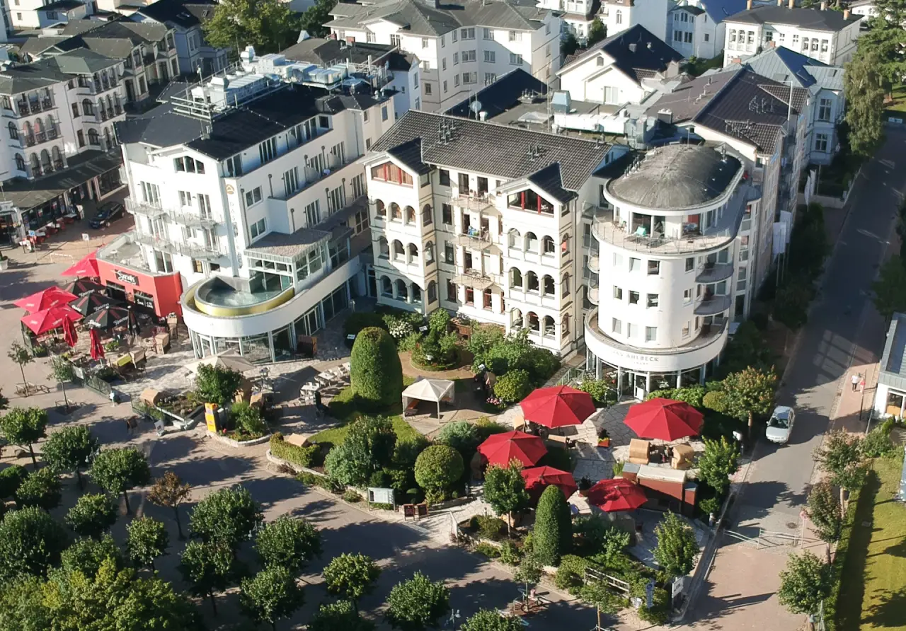 Luftaufnahme des Das Ahlbeck Hotel & Spa mit Hotelgebäuden, Dachpool, Garten und Terrassenbereich an der Ostsee.