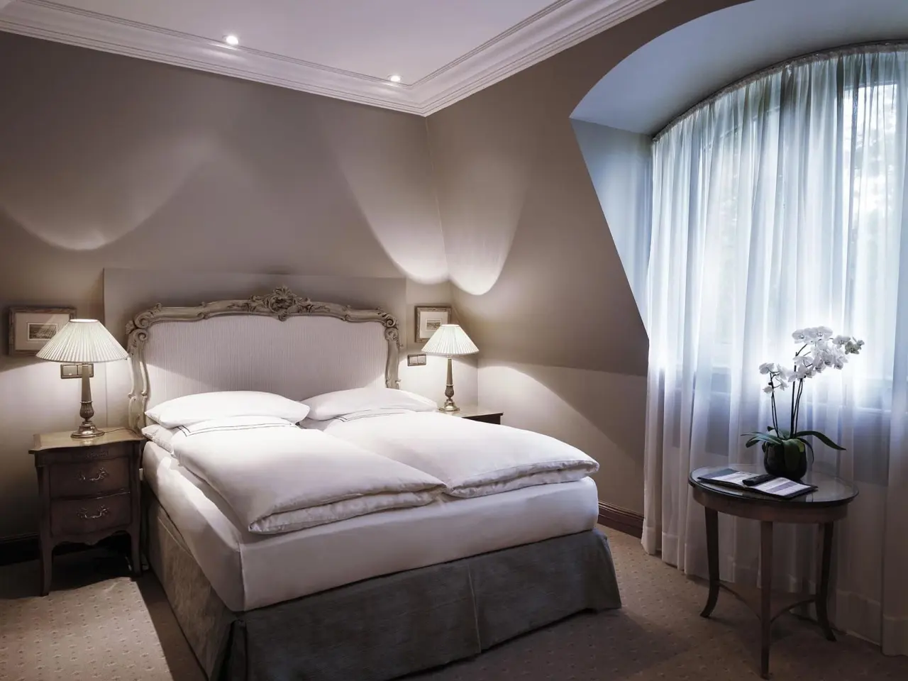 Elegantes Doppelzimmer mit klassischem Dekor, bequemen Betten und Fenster im Patrick Hellmann Schlosshotel.