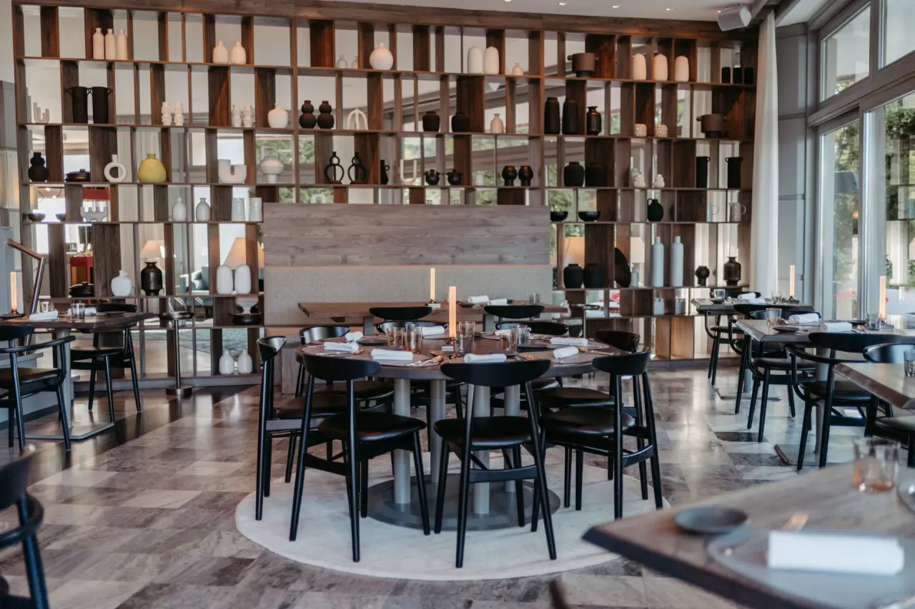 Modernes Restaurant im Hotel Parks Velden mit stilvoller Einrichtung, Holzelementen und Blick ins Grüne.