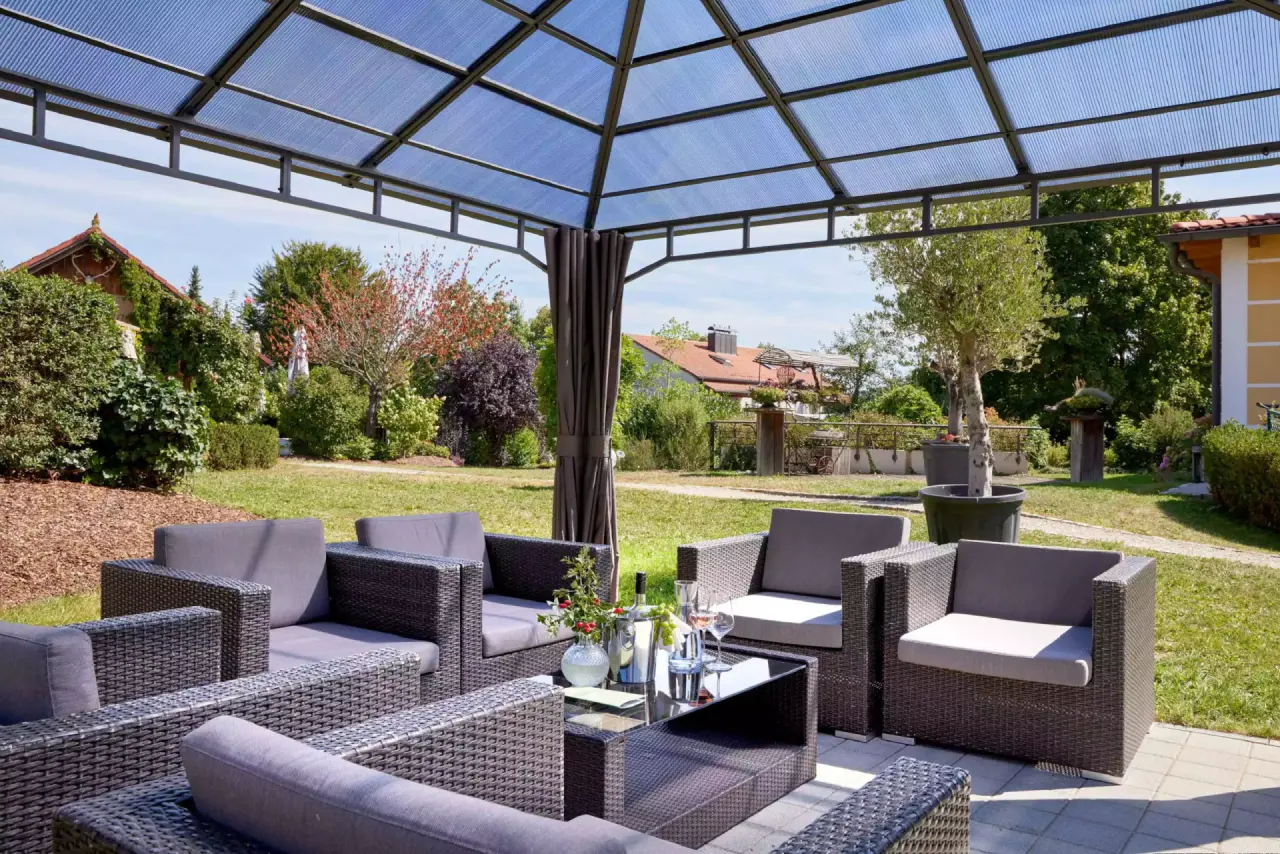 Gemütliche Lounge-Ecke unter einer Pergola im Garten des Götzfried**** Kultur- und Spahotels, ideal zum Entspannen.