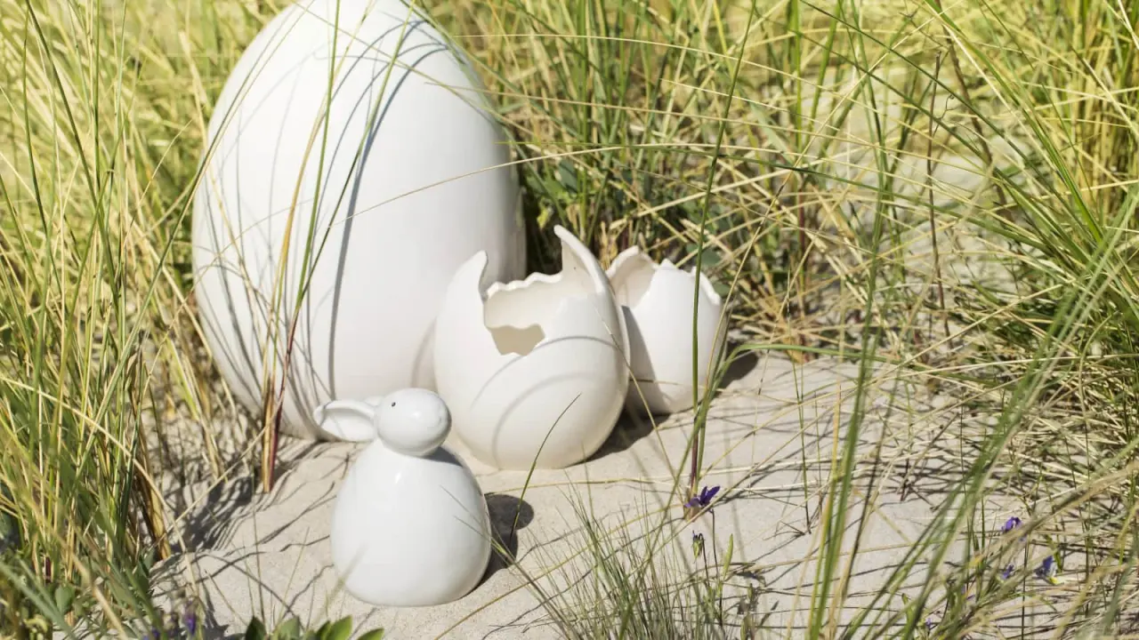 Osterdekoration mit Keramik-Eiern und Hase im Dünensand des Strandhotel Dünenmeer.