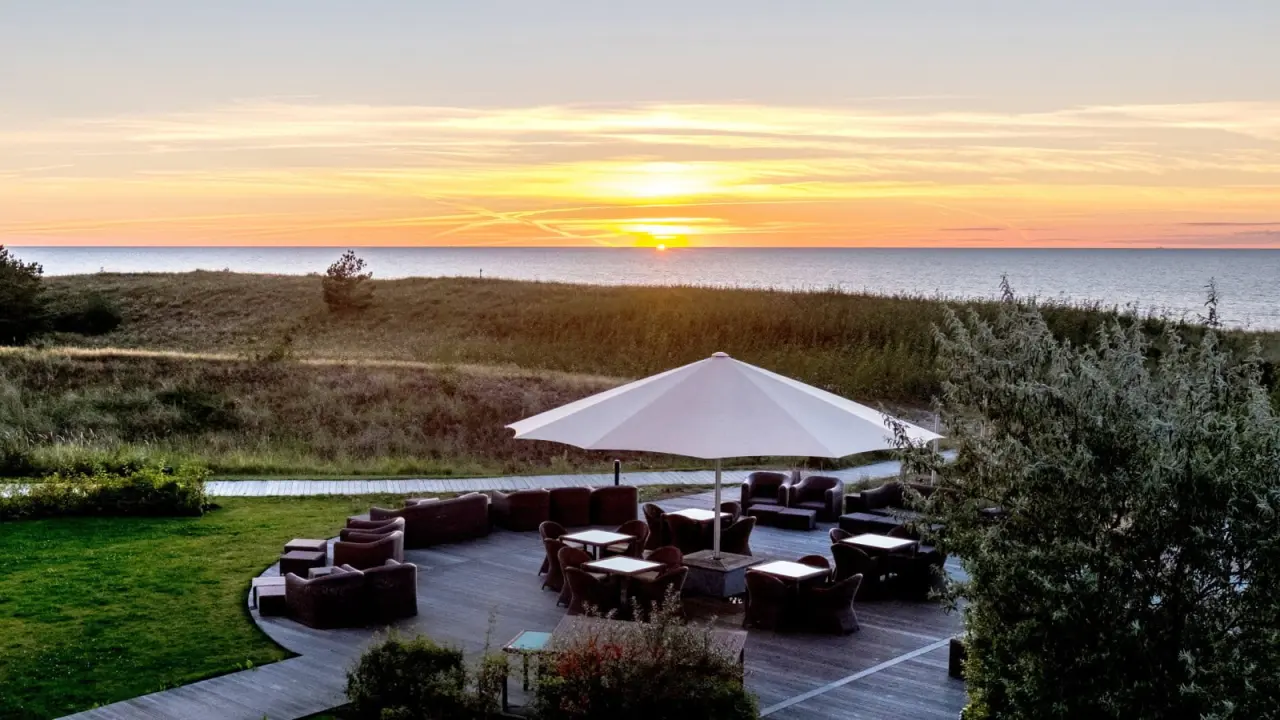 Abendstimmung auf der Terrasse des Strandhotel Dünenmeer mit Meerblick und Sonnenuntergang über der Ostsee.