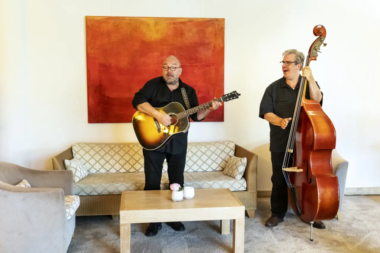 Musiker spielen Gitarre und Kontrabass in der Lobby des Strandhotel Dünenmeer.