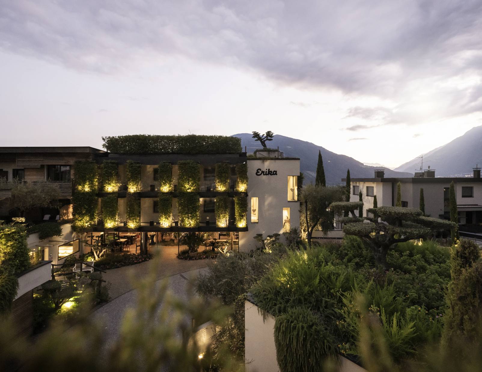 SPA & Relax Hotel Erika in Dorf Tirol – Beleuchtete Hotelfassade bei Dämmerung mit Bergblick | Wellnesshotel Südtirol