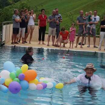 Gäste und bunte Ballons im Aussenpool des Der Kleinwalsertaler Rosenhof.