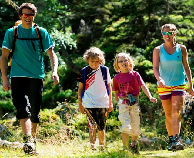 Glückliche Familie beim Wandern in der Natur rund um das Hotel Goldried, ideal für aktive Ferien.