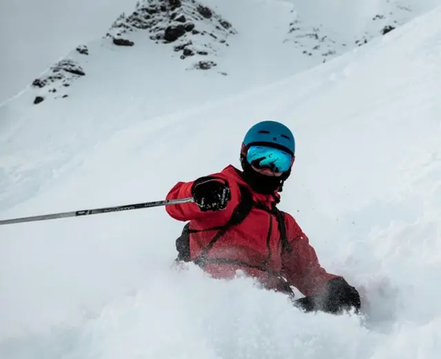 Skifahrer im Tiefschnee mit Bergpanorama, ein Wintererlebnis nahe dem Hotel Goldried.