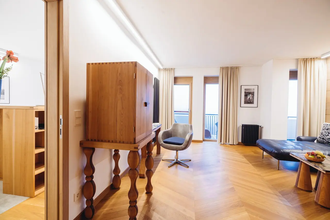 Geräumiges und helles Hotelzimmer mit Holzboden, modernem Mobiliar und Balkonzugang im Hotel Reiters Finest Family.