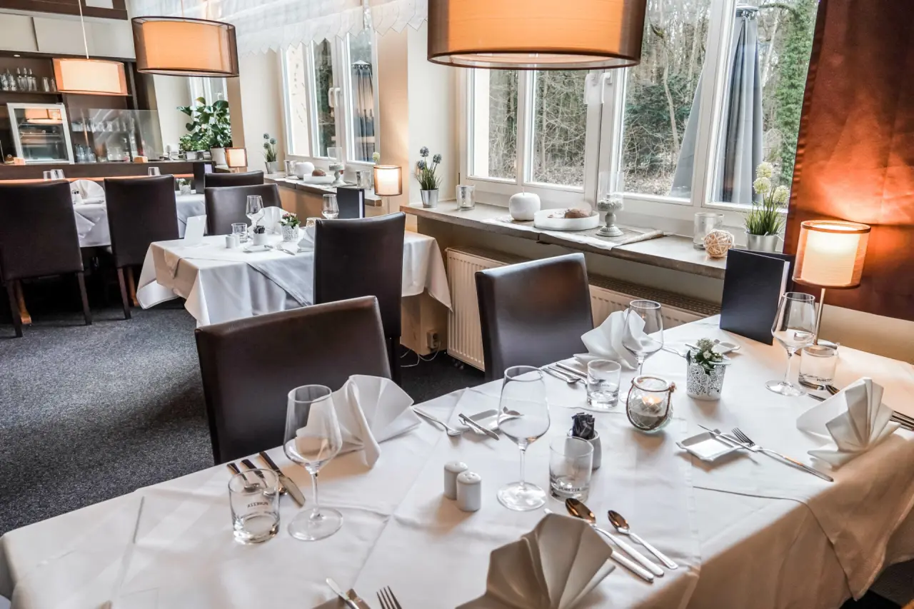 Elegant gedeckter Restaurantbereich mit Blick ins Grüne im Wellness- & Sporthotel 'Haus am See'.