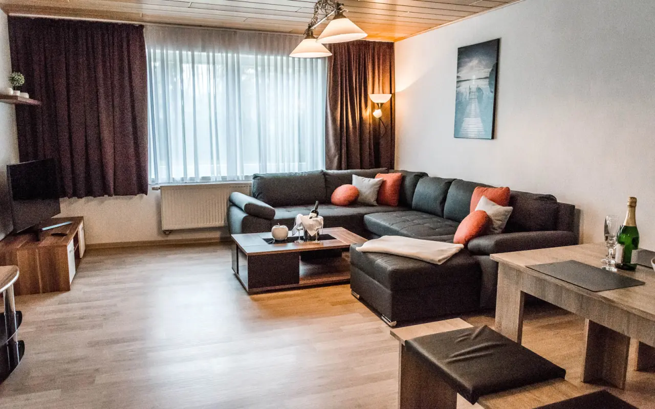 Gemütliches Wohnzimmer einer Suite mit Ecksofa und Esstisch im Wellness- & Sporthotel Haus am See.